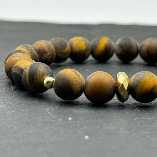 Aproce no dabīgiem un neapstrādātiem Tīģeracs (Tiger's Eye) akmeņiem